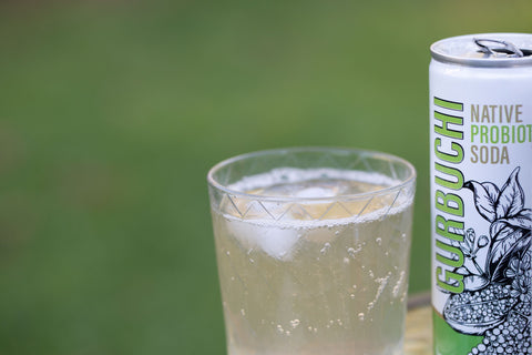 Close up image of a can of Gurbuchi Native Probiotic Soda, Lemon Myrtle and Finger Lime flavour, next to a glass full of refreshing Gurbuchi